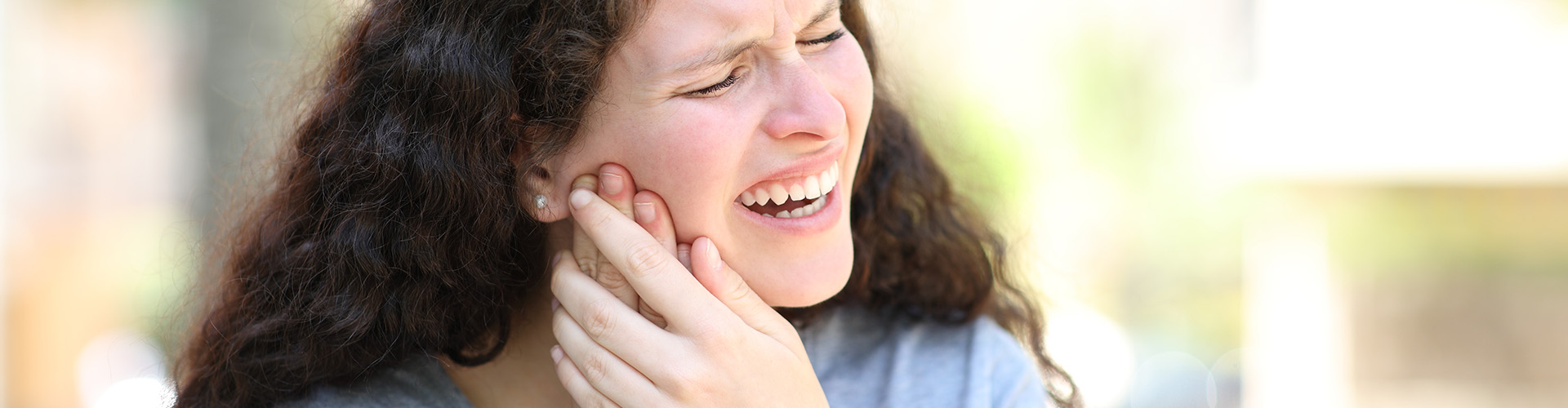 Female holding her jaw.