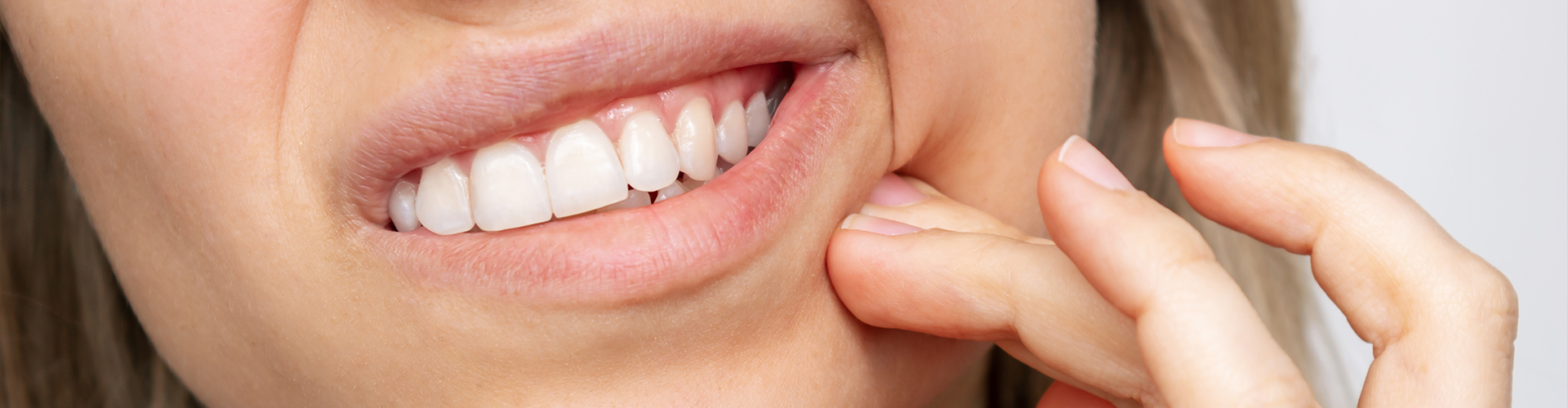 woman holding her cheek in pain