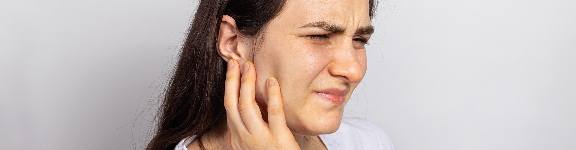 woman holding her jaw in pain