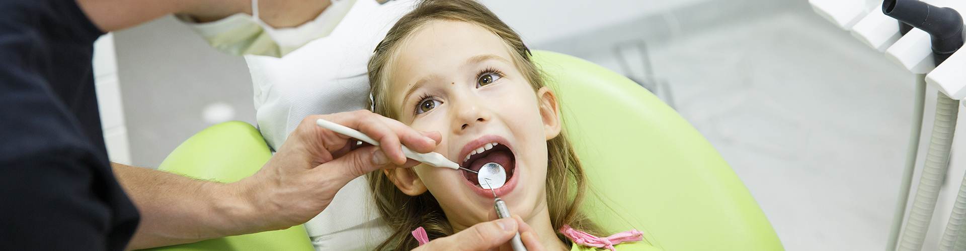 dentist using dental tools inside child's mouth
