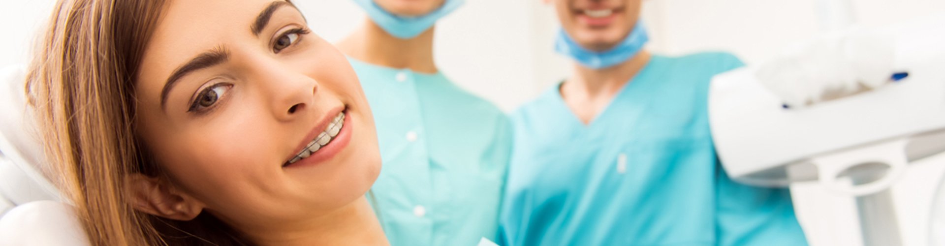 female wearing braces in front of dental professionals