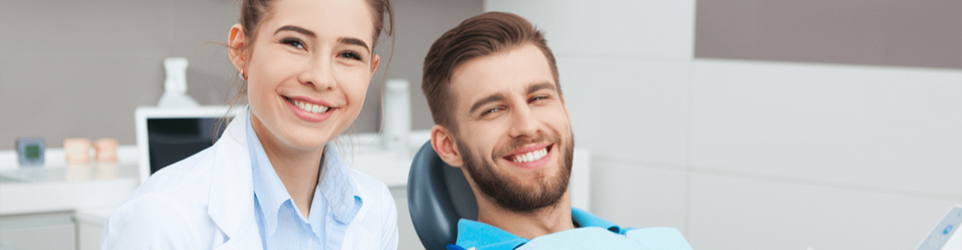 Male patient and female dentist smiling.