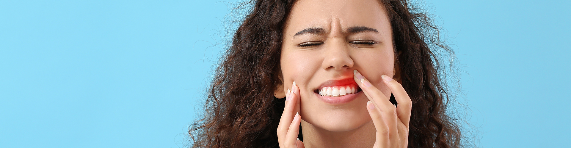 Woman holding her mouth in pain.