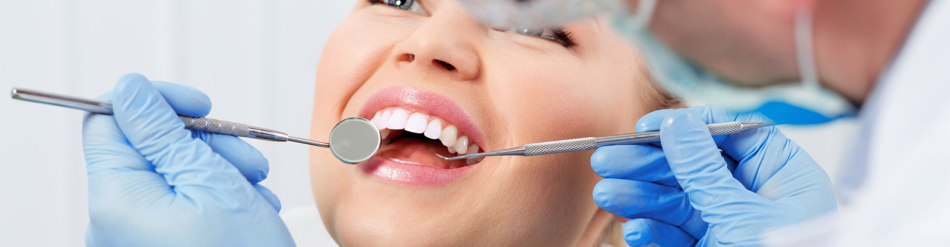 A woman with her mouth open receiving dental treatment.