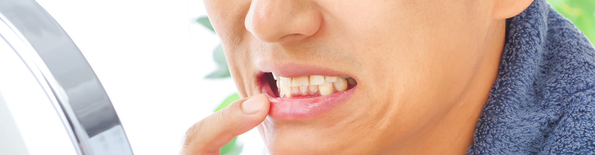 man pulling down lip to show inflamed gums