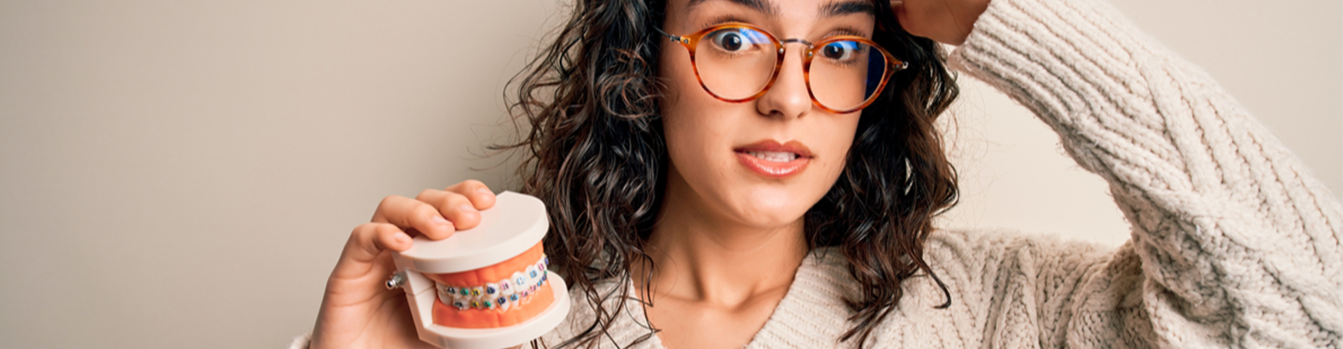 Anxious woman holding mouth model.