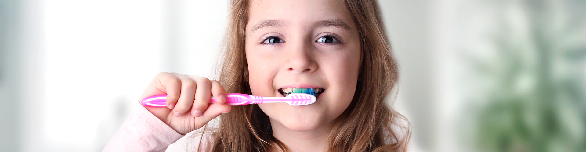 young girl brushing her teeth