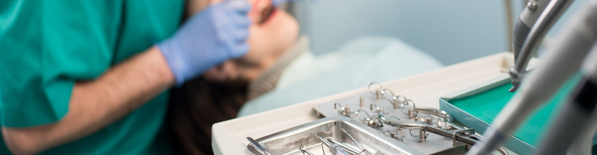 Patient in dental chair receiving treatment from dentist.