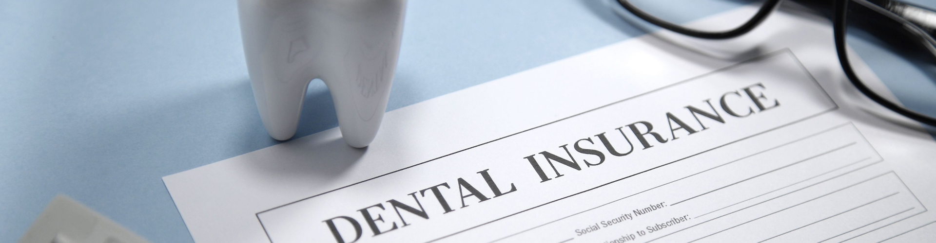 giant tooth beside a dental insurance form