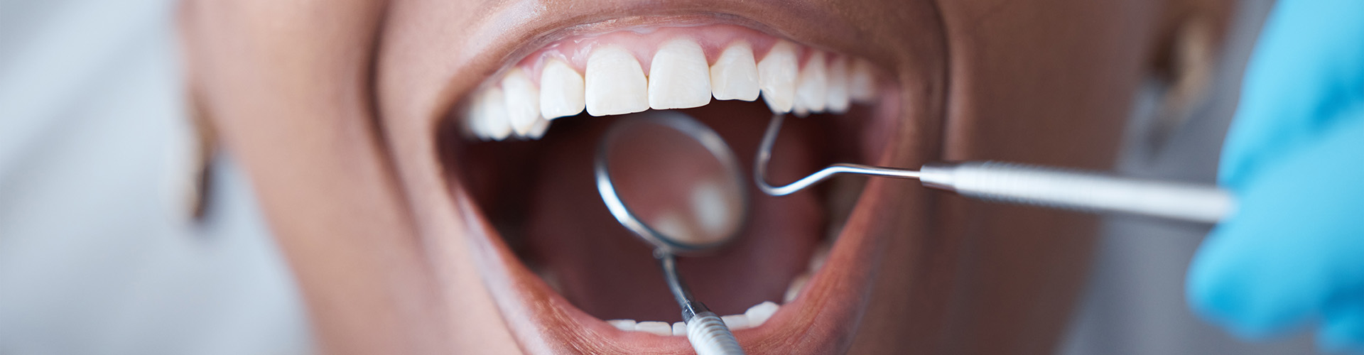 dentist using dental tools in persons mouth