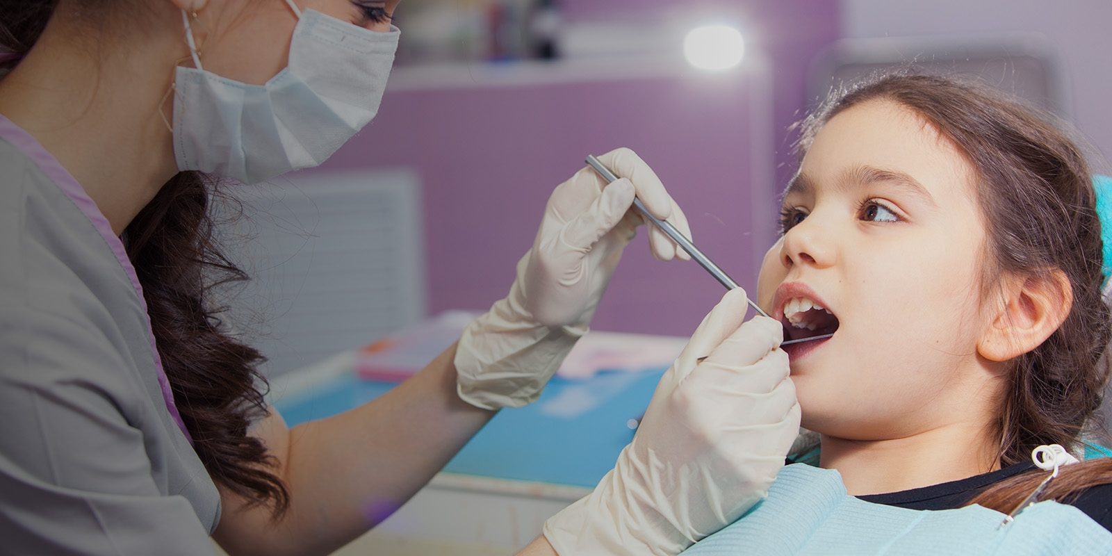 A dentist working with a child patient.