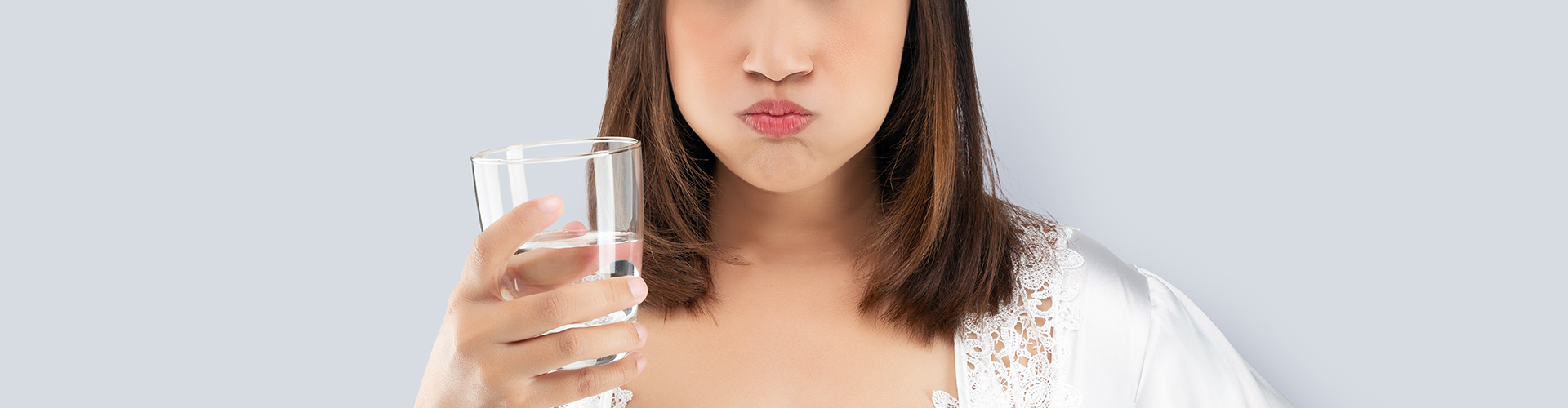 woman with cup swishing water in her mouth