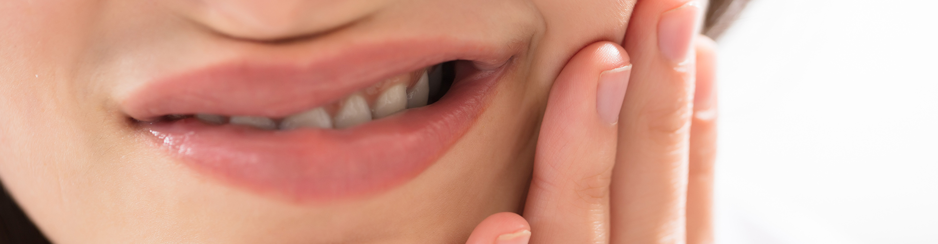 Woman holding her jaw in pain.