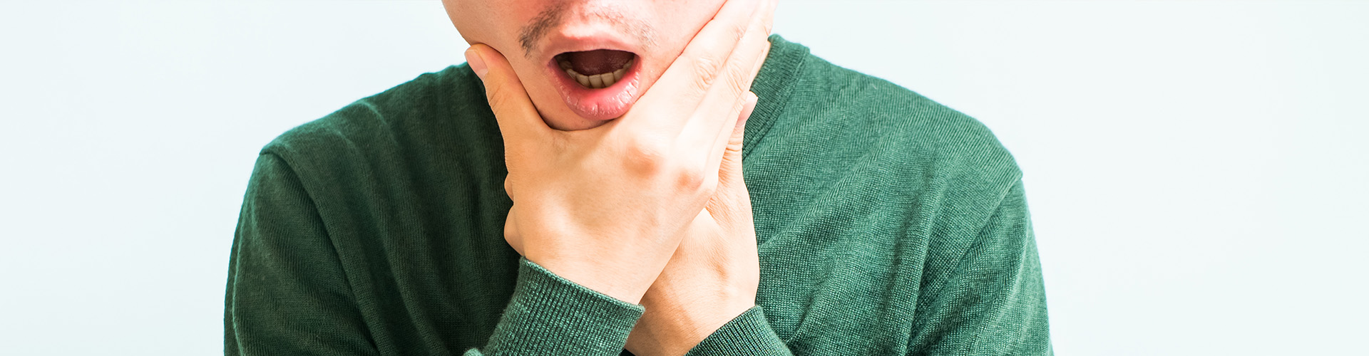 man holding jaw with both hands