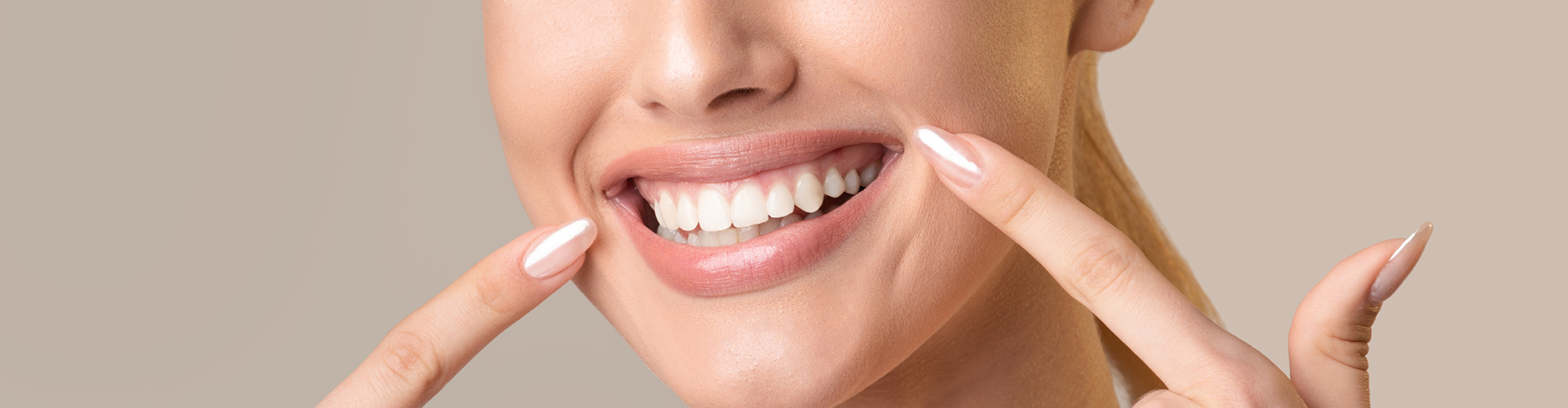 woman pointing to her smile with the first finger of each hand