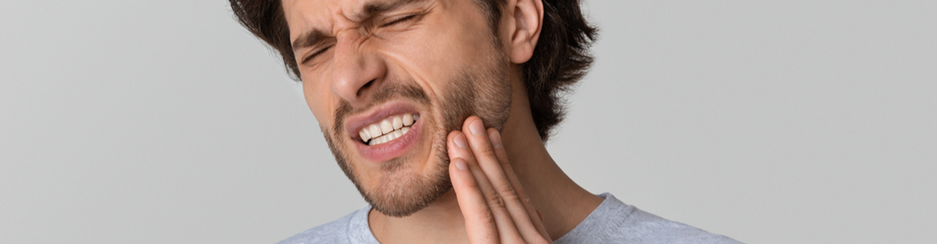 man holding jaw in pain