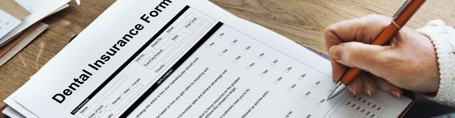 Person filling out dental insurance form.