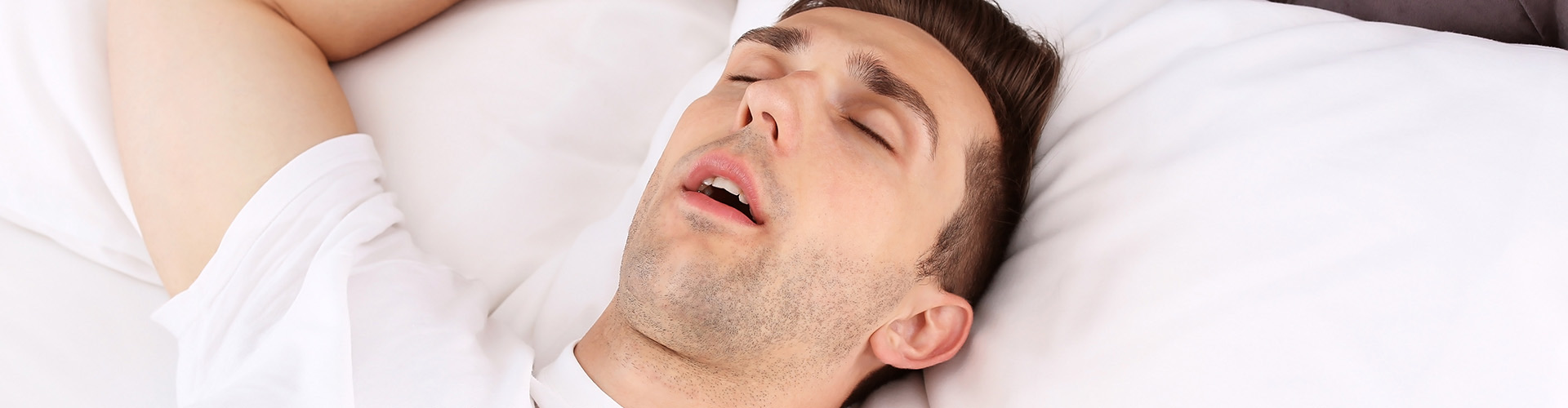 man sleeping on his with arm above his head