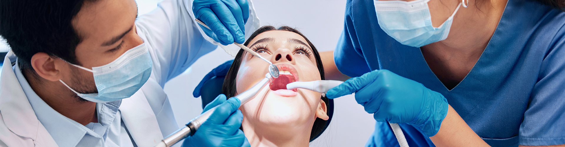two dentists holding dental tools in patients mouth