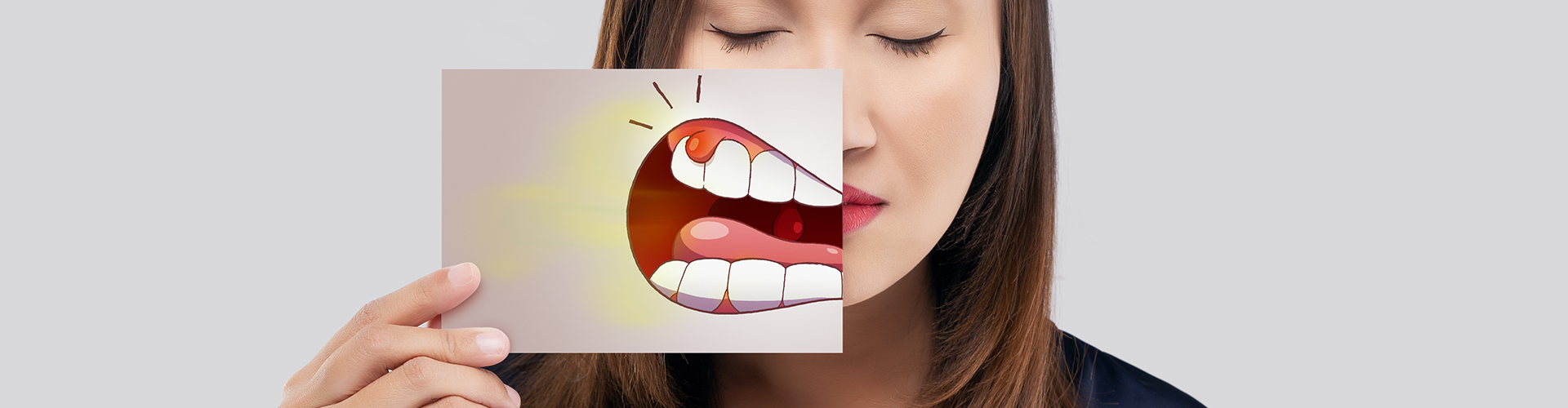 woman holding a dental absess illustration in front of her mouth
