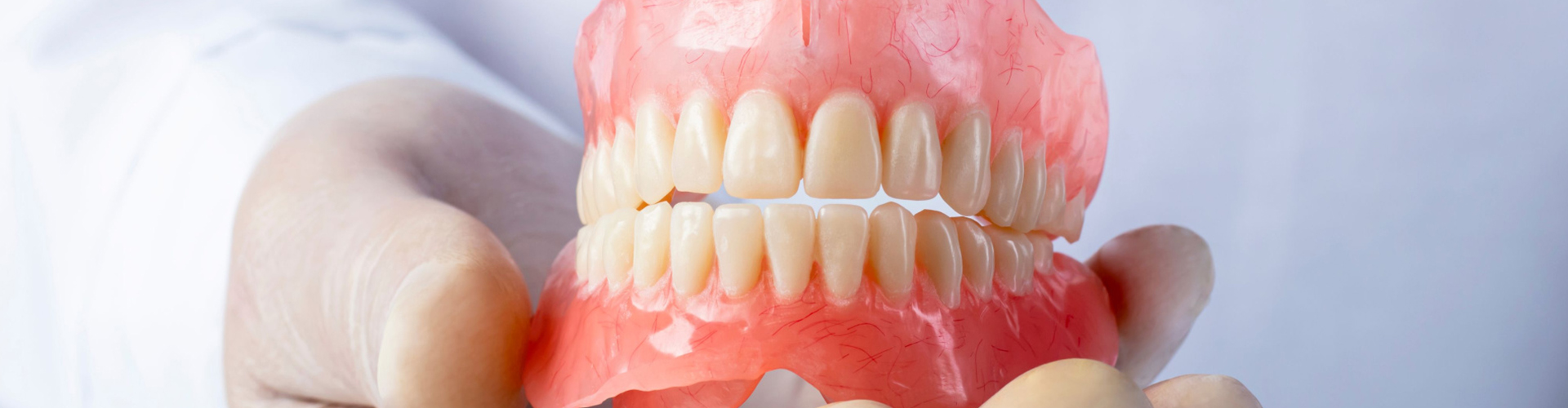 hand holding a set of dentures