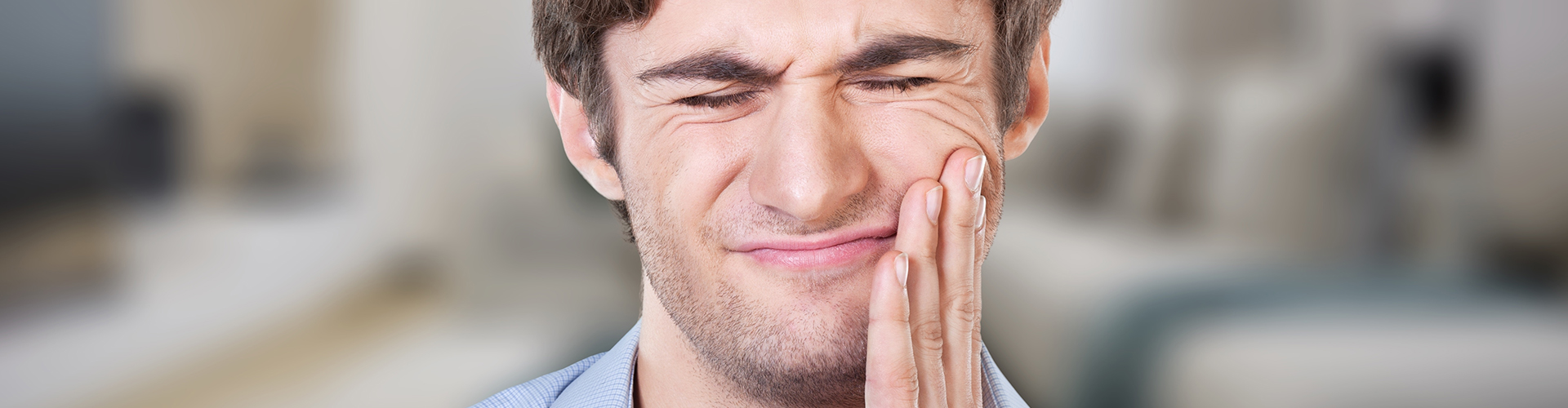 man holding his cheek in pain