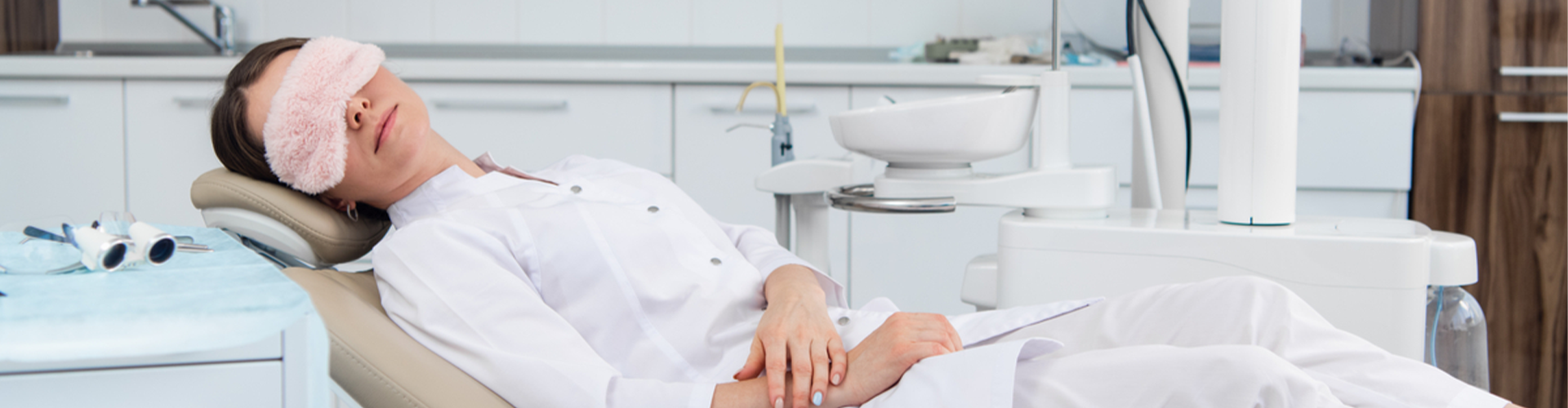 Woman wearing sleep mask in dental chair.