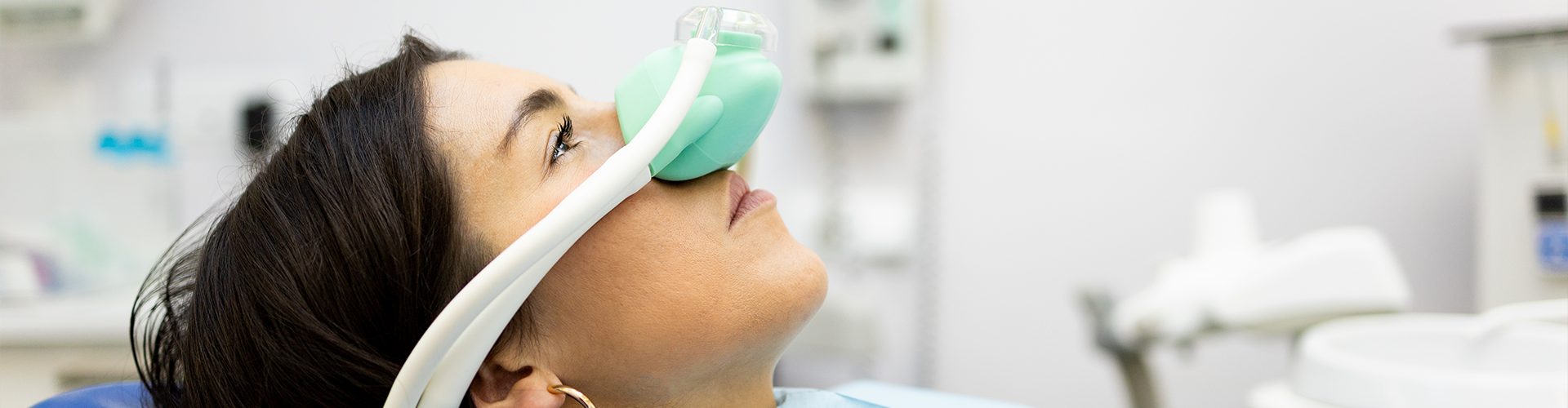 women in dental chair with breathing mask on her nose