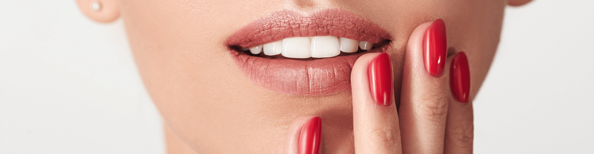 Female holding hand by mouth while smiling.