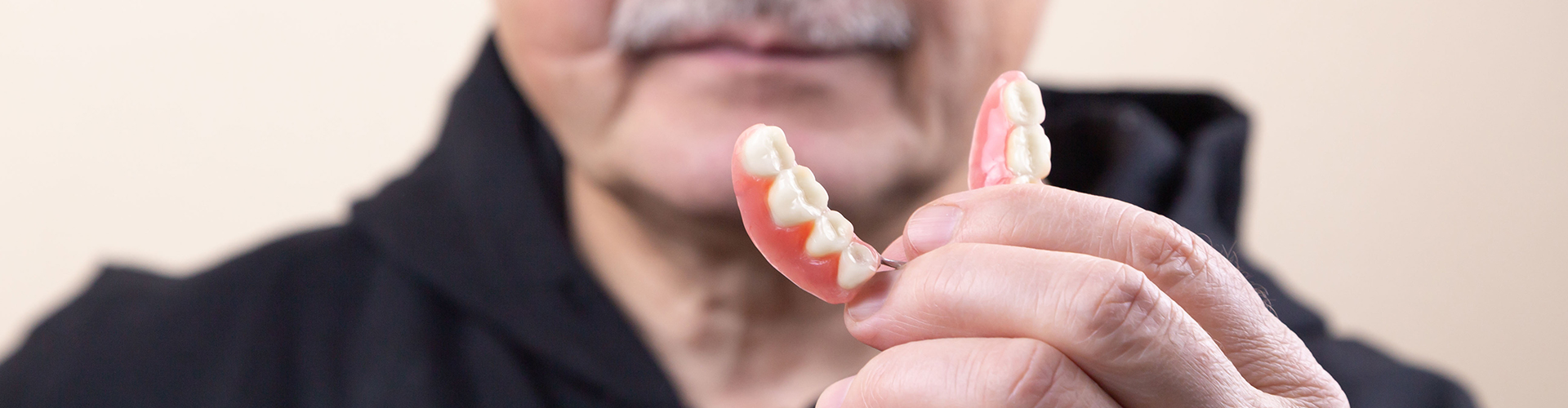 Man holding a lower denture.