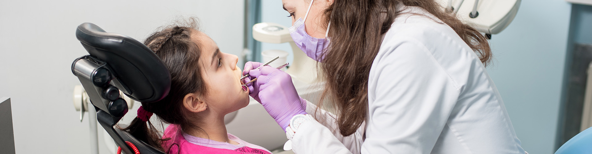 A dentist working with a child patient.