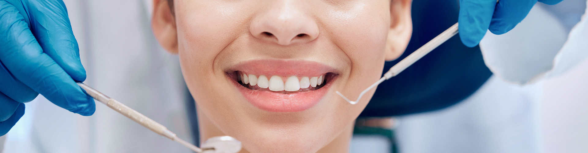 dental tools held beside smiling woman