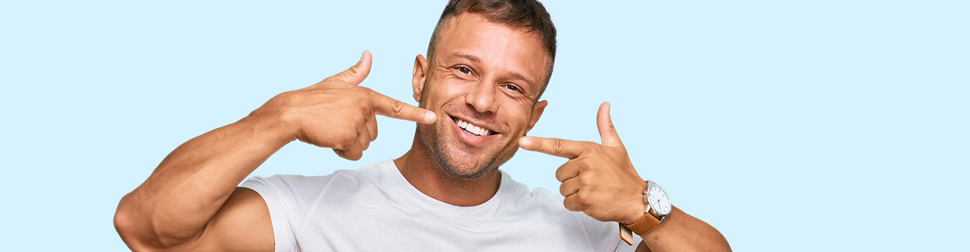 man pointing at his smile with both hands