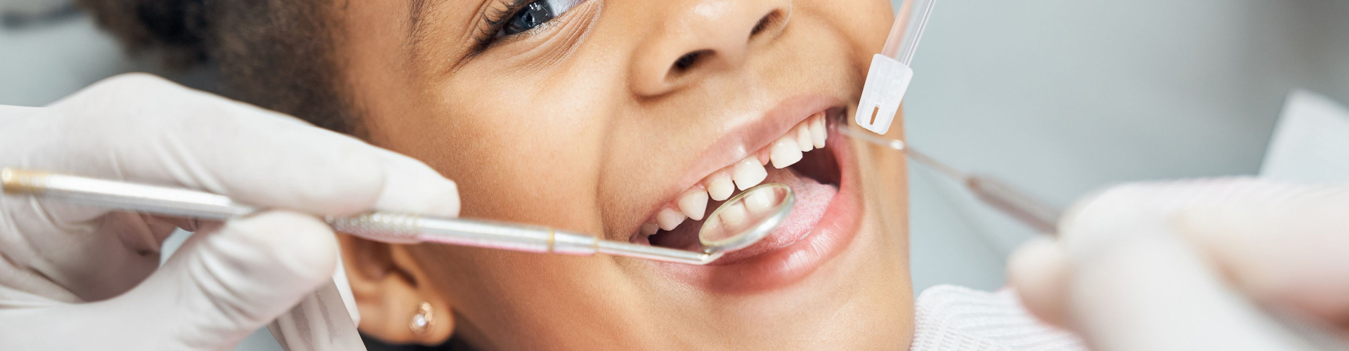 Smiling child being examined by the dentist.